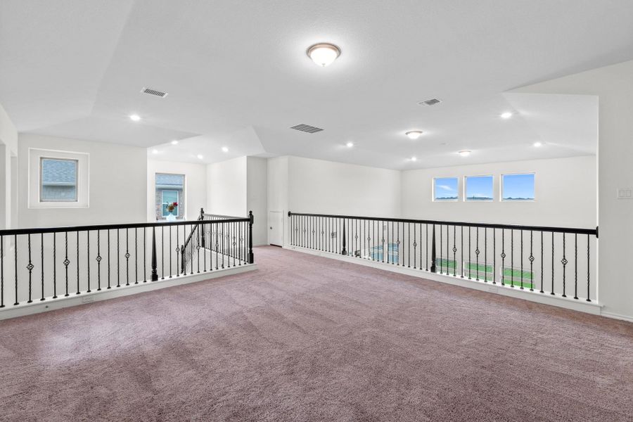Expansive upper-level loft area with plush carpeting and crisp white walls
