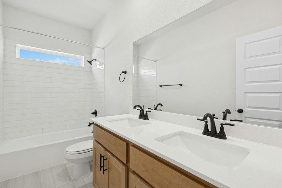 Full bathroom featuring double vanity and shower / tub combination