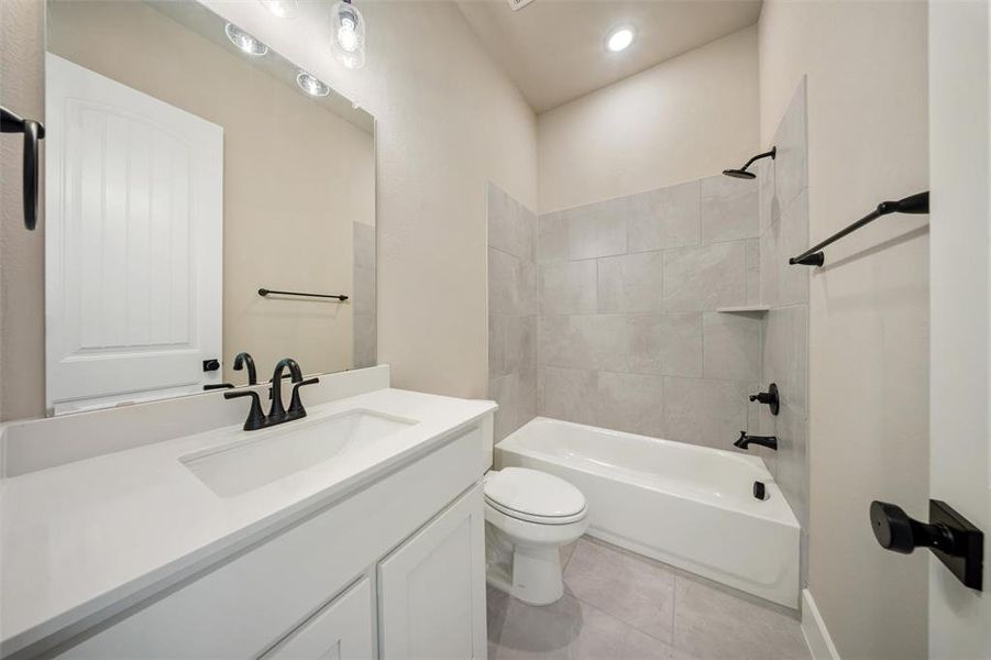 Bathroom featuring vanity, bathing tub / shower combination, tile patterned floors, and recessed lighting Bathroom featuring vanity, bathing tub / shower combination, tile patterned floors, and recessed lighting