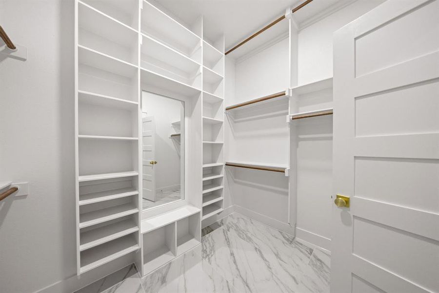 Custom closet system featuring extensive shelving, integrated mirror, dedicated shoe storage, and hanging rods Custom closet system featuring extensive shelving, integrated mirror, dedicated shoe storage, and hanging rods