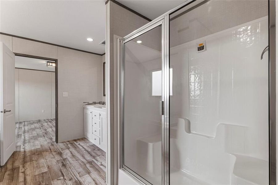 Full bathroom with vanity, a stall shower, ornamental molding, recessed lighting, and light wood-style floors