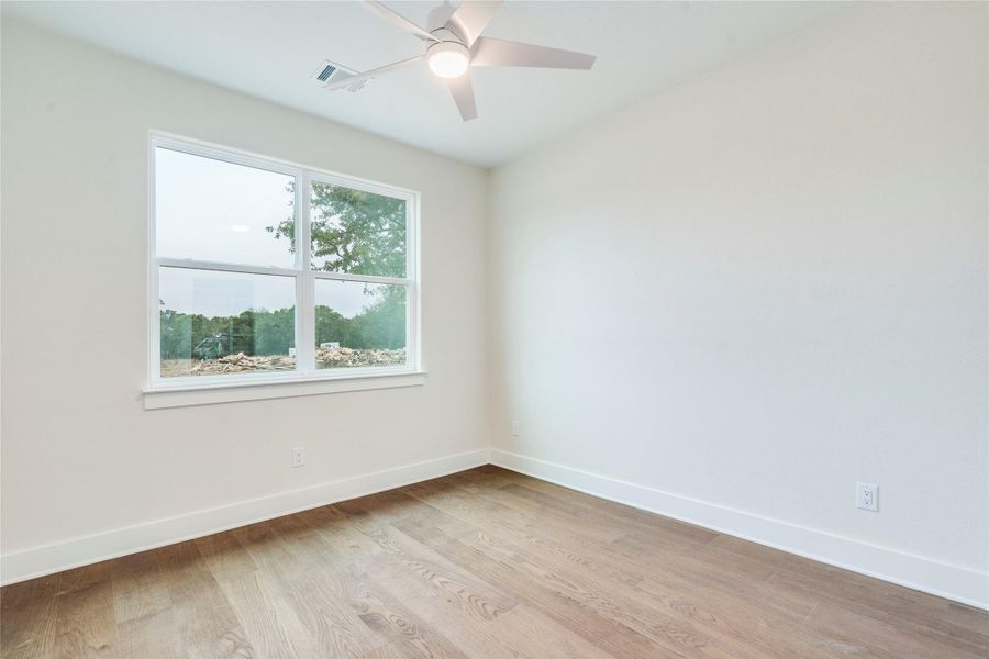 Unfurnished room featuring light wood-style flooring and a ceiling fan