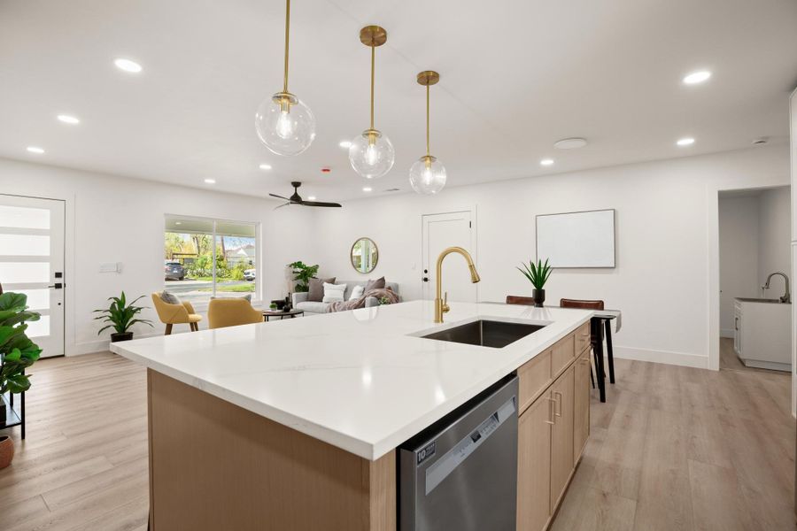 Kitchen with a center island with sink, ceiling fan, dishwasher, and light wood finished floors