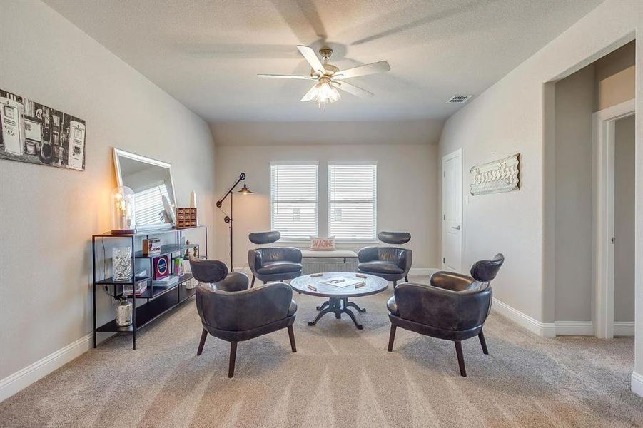 Sitting room featuring light carpet and ceiling fan