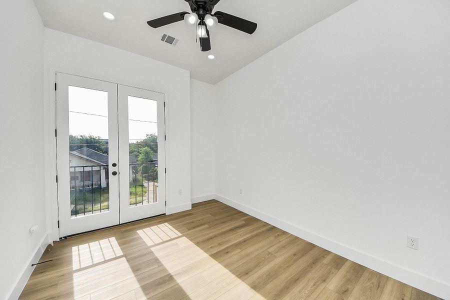 Bright guest bedroom with abundant natural light and a clean, modern feel.