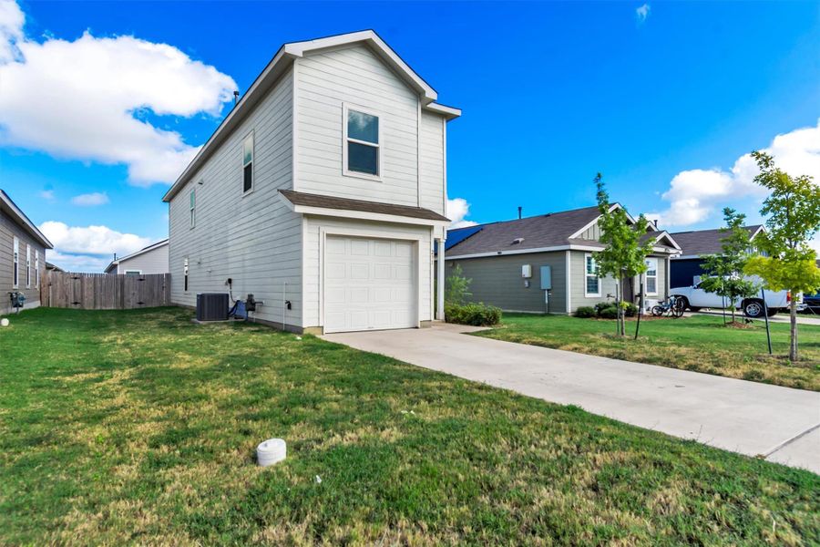 A concrete driveway leads to the attached garage of this two-story residential home. A concrete driveway leads to the attached garage of this two-story residential home.