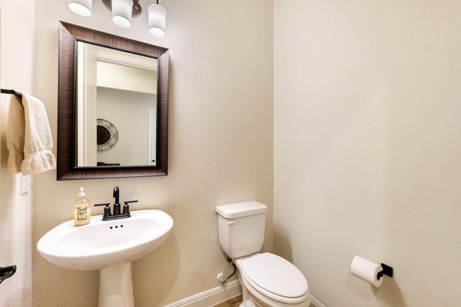 A well-appointed powder room features a classic pedestal sink and modern fixtures. A well-appointed powder room features a classic pedestal sink and modern fixtures.