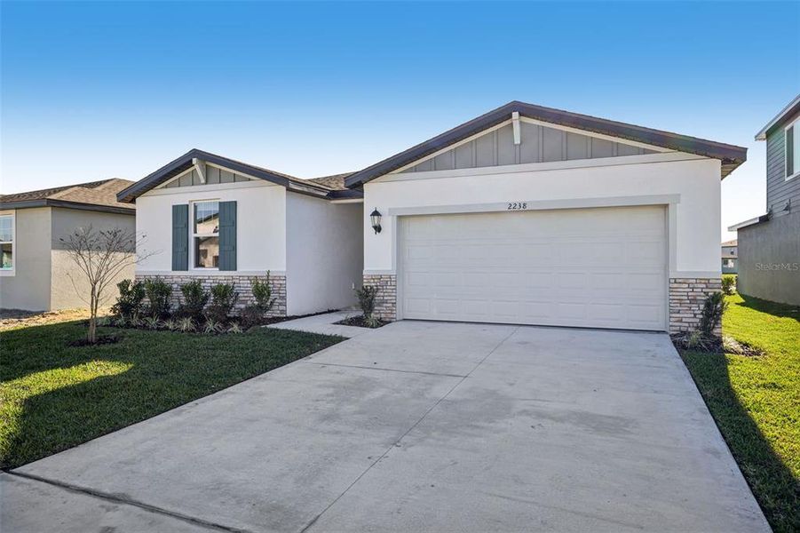 Front exterior of a new home in The Grove at Stuart Crossing - Classic Series, Bartow, FL, highlighting curb appeal (Image 21).