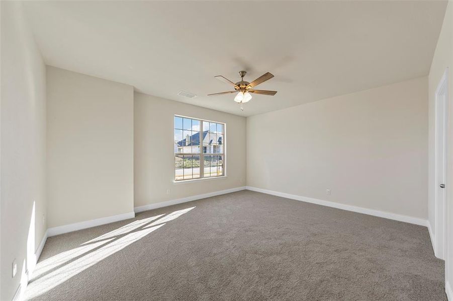 Carpeted spare room with ceiling fan