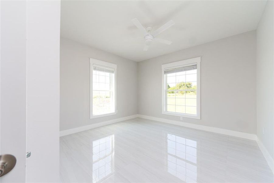 4th bedroom with light tile patterned floors and ceiling fan