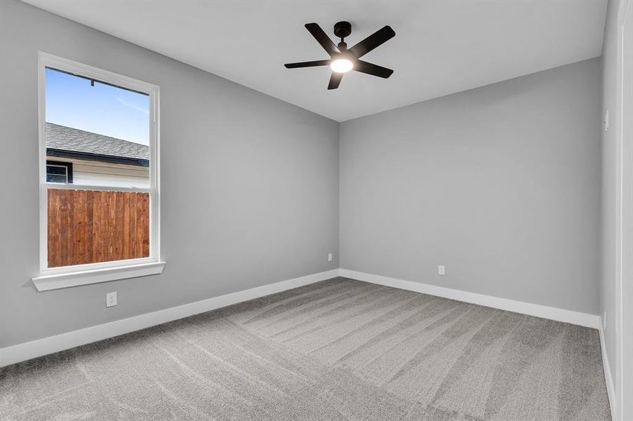 Unfurnished room featuring carpet floors and ceiling fan