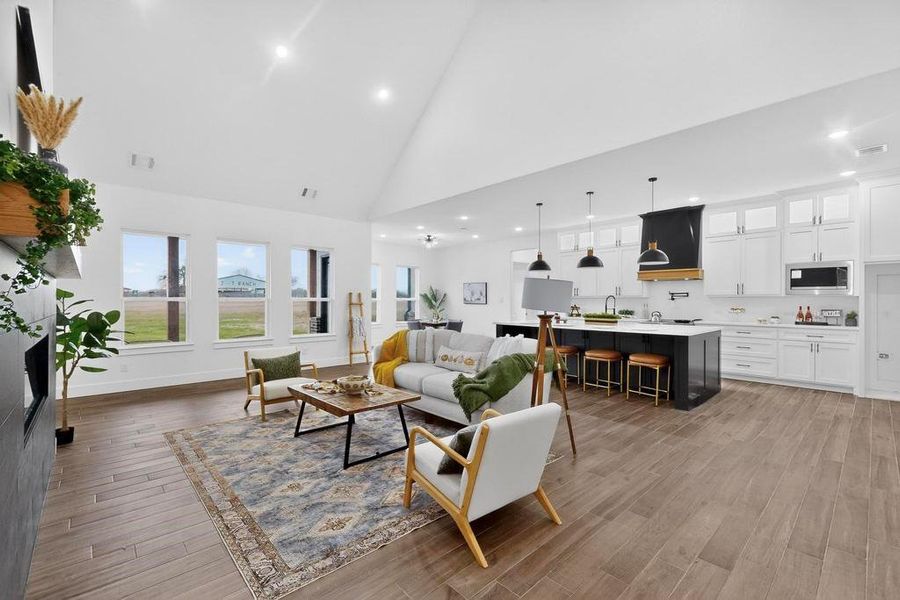 Living room featuring high vaulted ceiling, recessed lighting, and light wood-style floors Living room featuring high vaulted ceiling, recessed lighting, and light wood-style floors