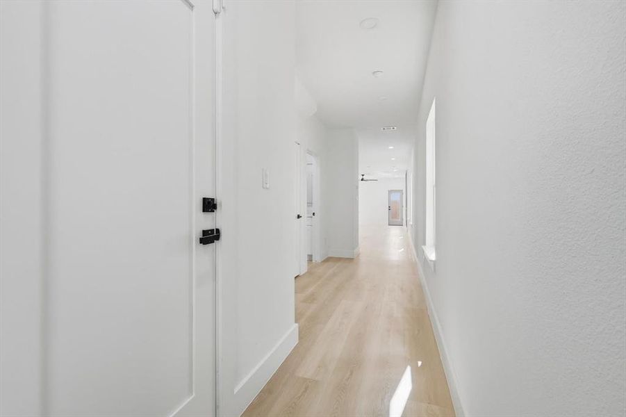 Corridor featuring light wood-type flooring and baseboards