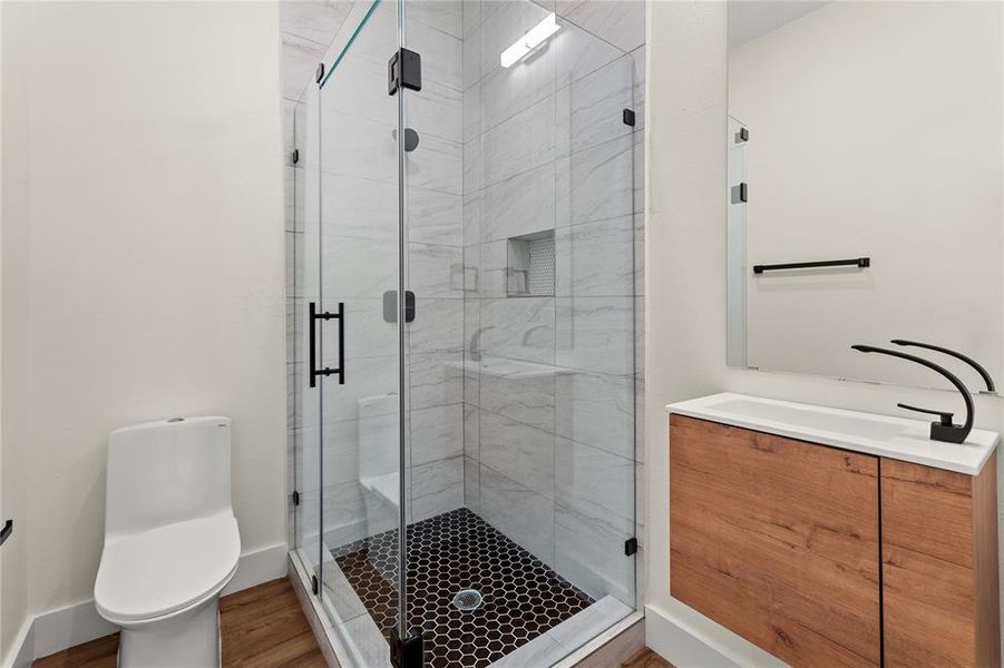 Bathroom featuring vanity, a shower stall, and wood finished floors