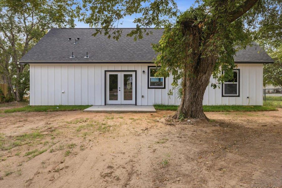 Board and batten siding meets a dark shingle roof, framing clean backyard access doors. Board and batten siding meets a dark shingle roof, framing clean backyard access doors.
