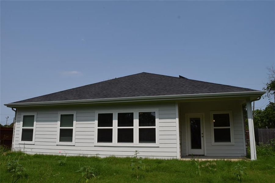 Back of property featuring a patio area and roof with shingles