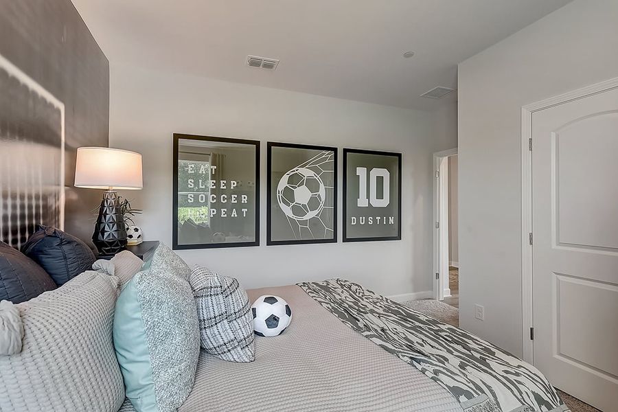 A bedroom with a bed and a lamp.