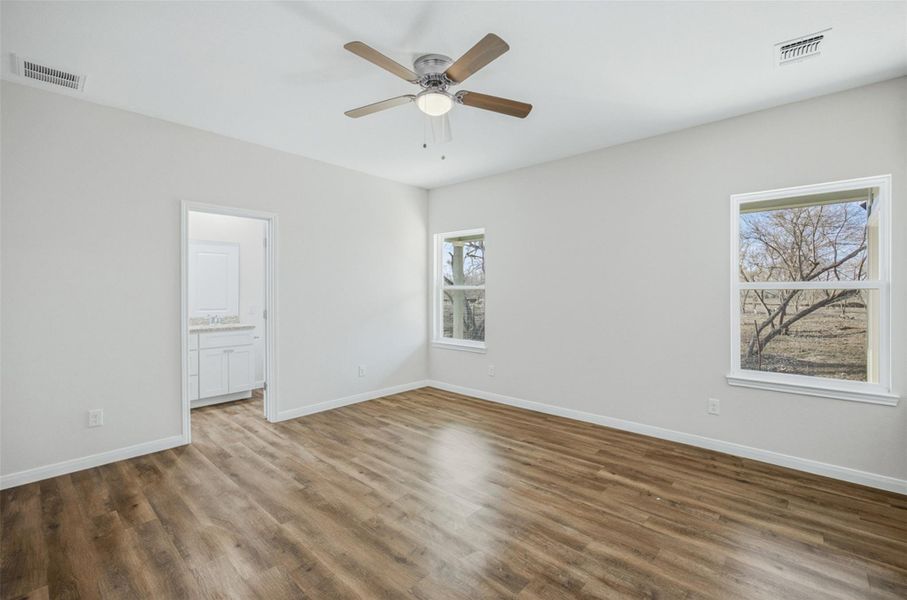 A tranquil bedroom with durable flooring and direct access to a private bath.