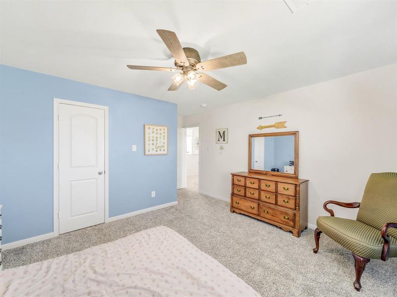 Carpeted bedroom featuring baseboards and a ceiling fan