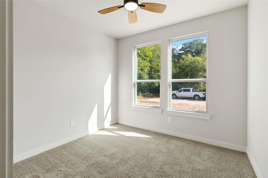Empty room featuring carpet flooring and ceiling fan