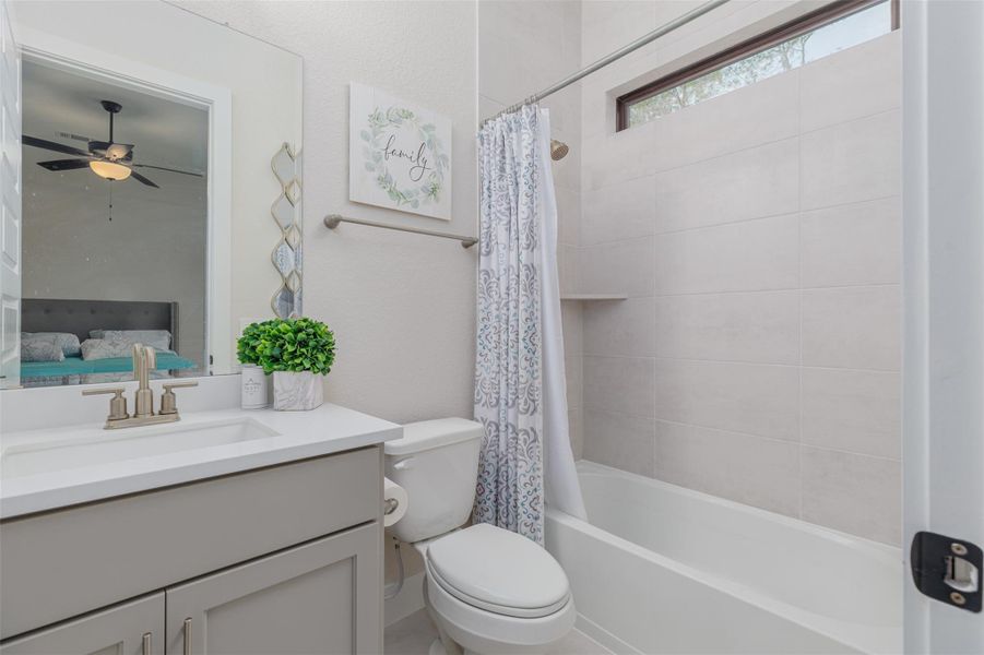 This ensuite bath offers a shower tub combination, fully tiled wall and a window to assist with the natural light.