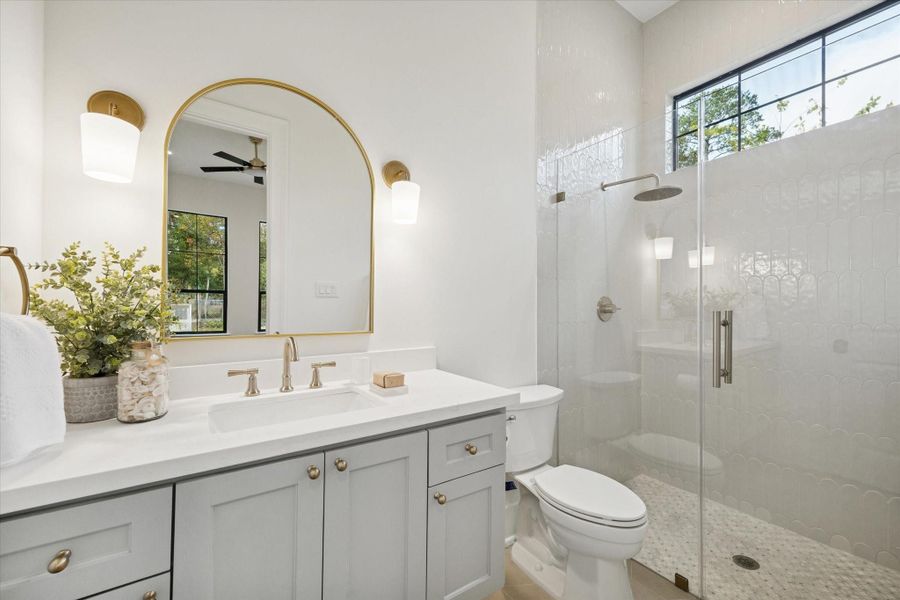 Full secondary guest suite bathroom with double sinks, modern fixtures, and frameless glass shower.