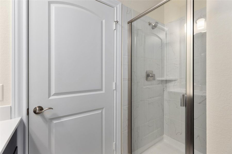 Bathroom with vanity and a marble finish shower