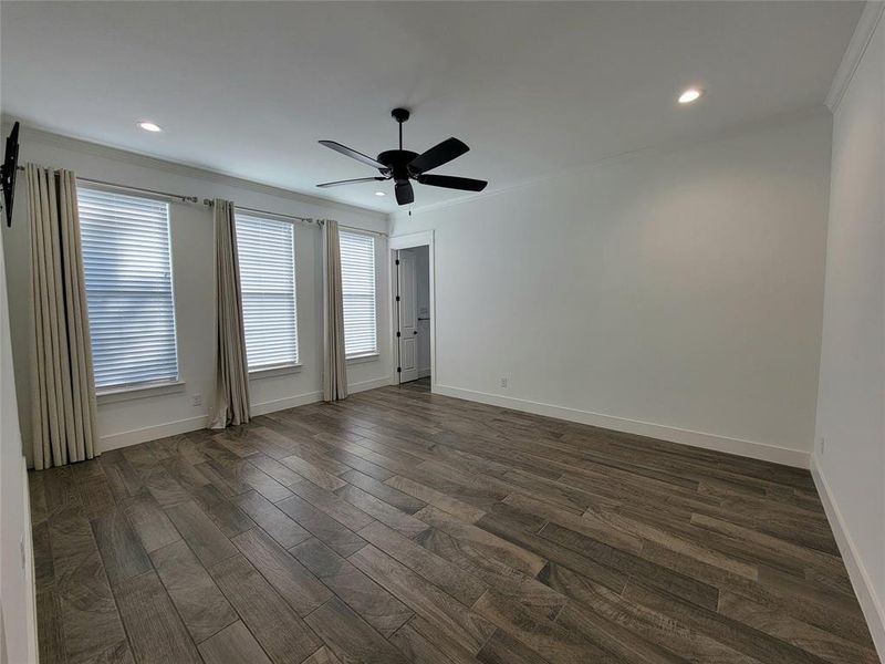 Master bedroom with crown molding and beautiful wood like tile flooring