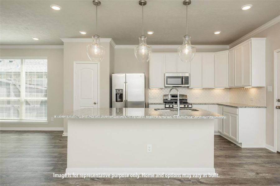 Kitchen featuring crown molding, decorative backsplash, stainless steel appliances, white cabinets, and light stone countertops