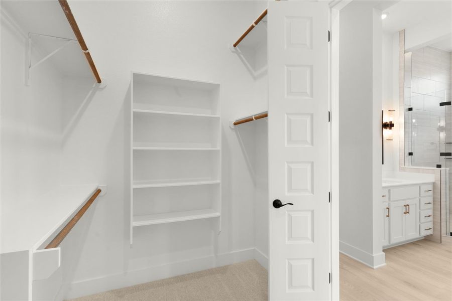 Walk in closet featuring light wood finished floors Walk in closet featuring light wood finished floors