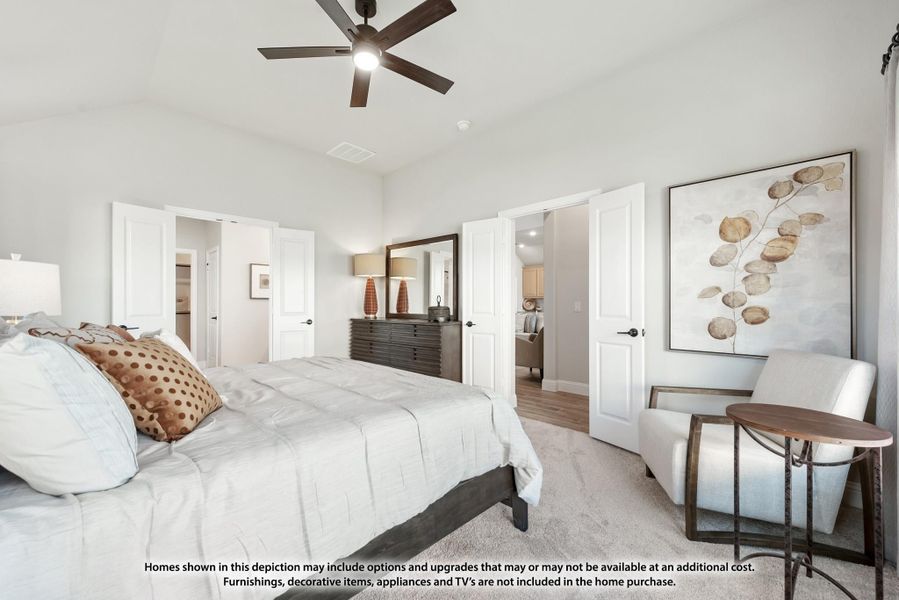 Master bedroom with ceiling fan, king bed, sitting chair, and doors leading to bathroom and closet