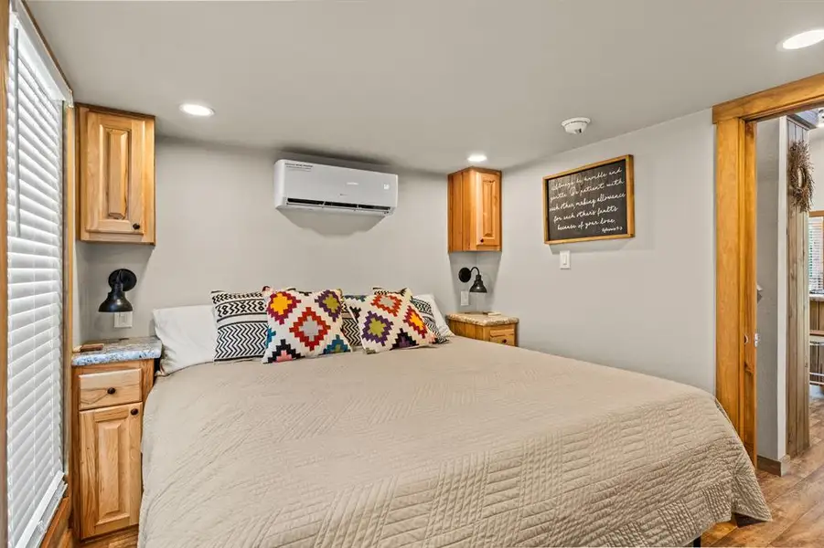 Bedroom with recessed lighting, light wood finished floors, and a wall mounted air conditioner