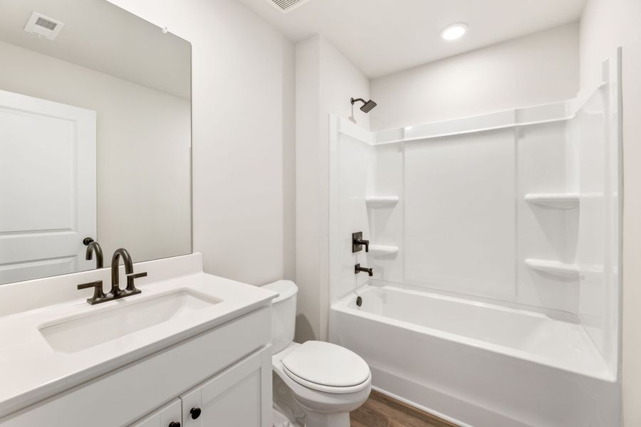 A bathroom with a tub sink and toilet. A bathroom with a tub sink and toilet.