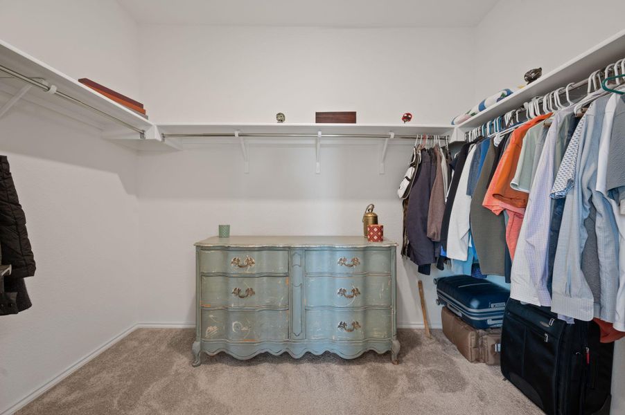 Walk in closet featuring light colored carpet