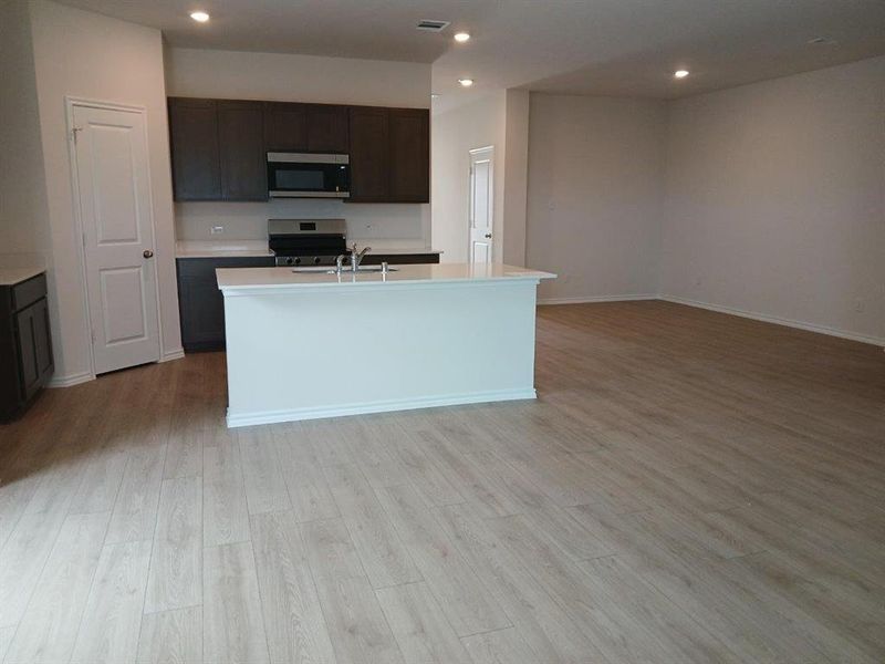 Open-concept living area featuring light wood-finish flooring Open-concept living area featuring light wood-finish flooring