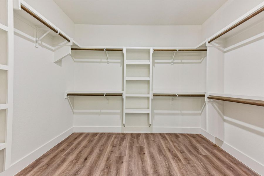 Walk in closet with light wood finished floors