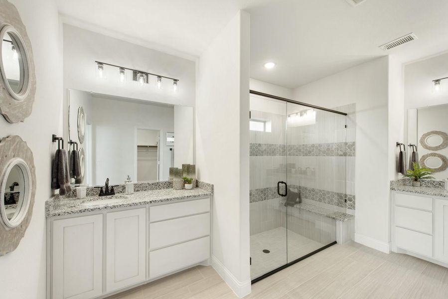 Master bathroom with dual vanities, granite countertops, and glass-enclosed walk-in shower with tile bench