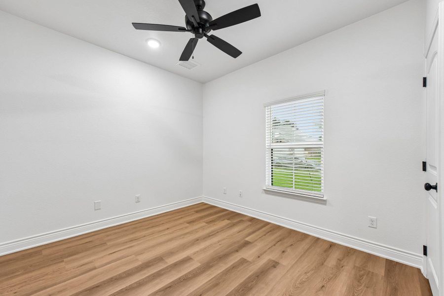 A well-lit room showcasing a ceiling fan, durable vinyl plank flooring, and a window with blinds for privacy. All secondary beds have 2 closets. A well-lit room showcasing a ceiling fan, durable vinyl plank flooring, and a window with blinds for privacy. All secondary beds have 2 closets.
