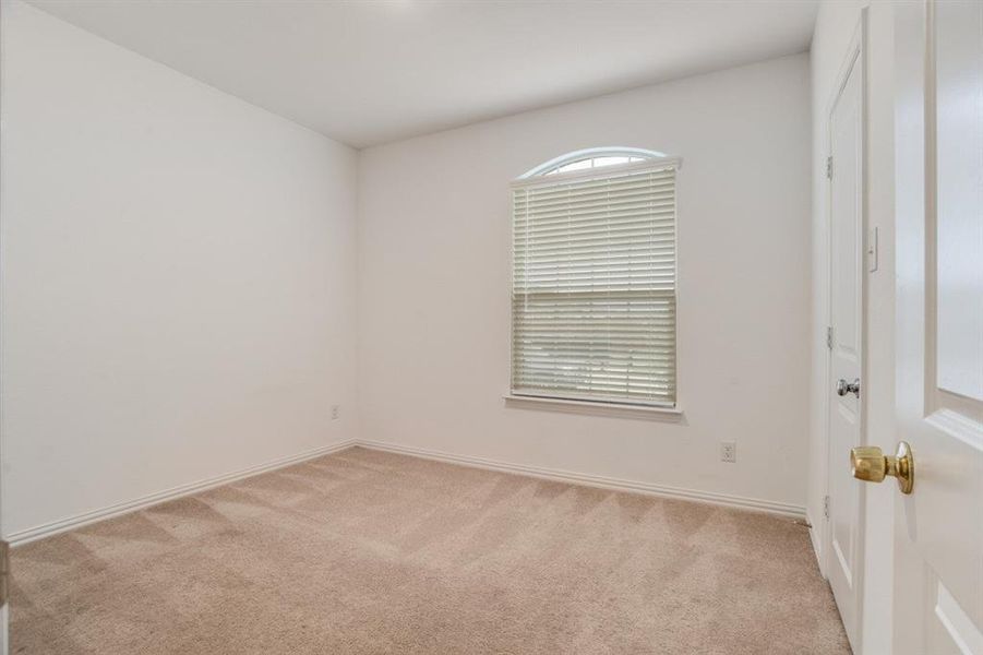 Unfurnished room featuring light carpet and baseboards
