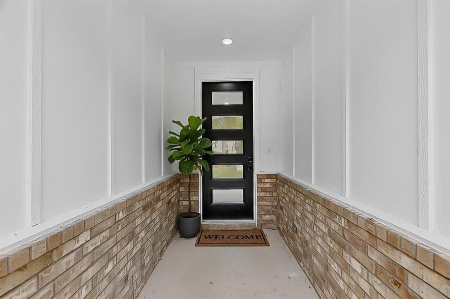 View of exterior entry with board and batten siding and brick siding View of exterior entry with board and batten siding and brick siding