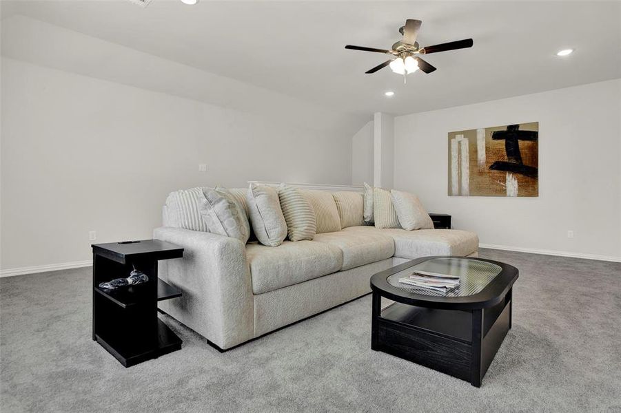 Living room with ceiling fan and carpet flooring