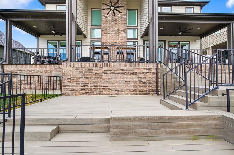Impressive rear elevation showcasing the multi-level outdoor living areas, covered patios, and dual ceiling fans overlooking the lake. Impressive rear elevation showcasing the multi-level outdoor living areas, covered patios, and dual ceiling fans overlooking the lake.
