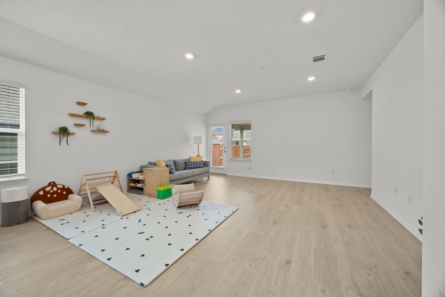 Living room featuring light wood-style floors, recessed lighting, and lofted ceiling