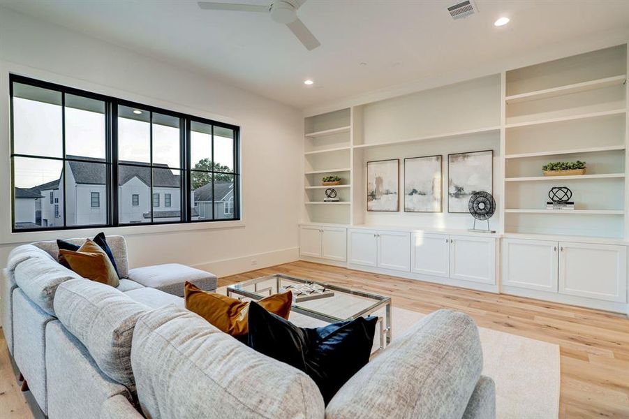 The open layout of this game room allows for versatile arrangements, accommodating everything from game nights to home theater setups. Large windows flood the room with natural light, creating a vibrant and energizing ambiance that adds to the overall appeal.