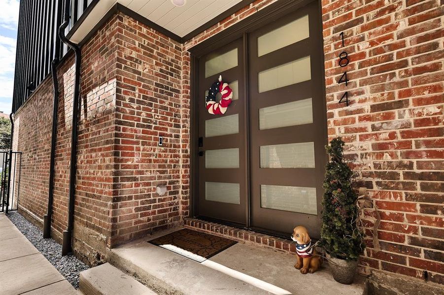 Secluded entrance to property featuring brick siding