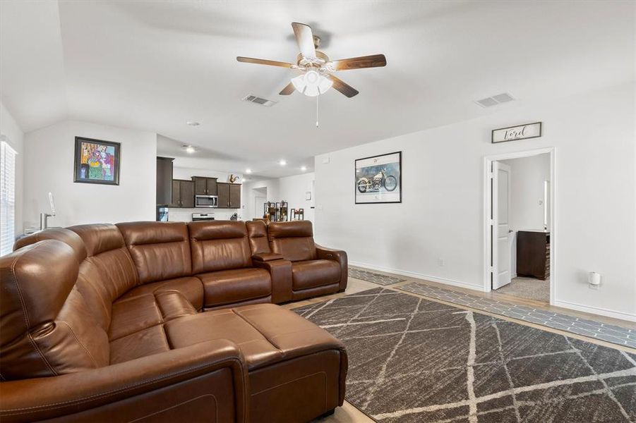 Living room featuring ceiling fan and lofted ceiling