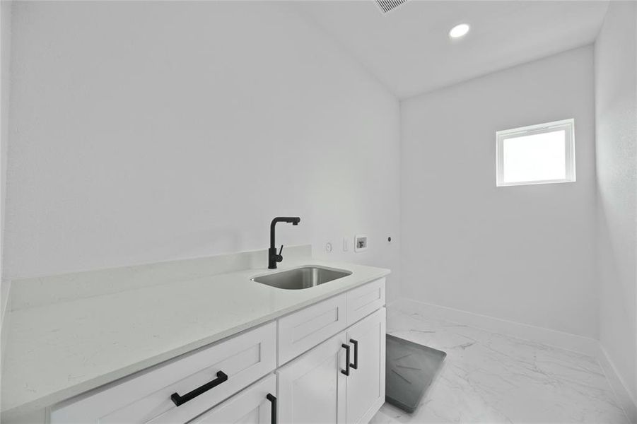 Laundry room with washer hookup, light marble finish flooring, recessed lighting, and cabinet space Laundry room with washer hookup, light marble finish flooring, recessed lighting, and cabinet space