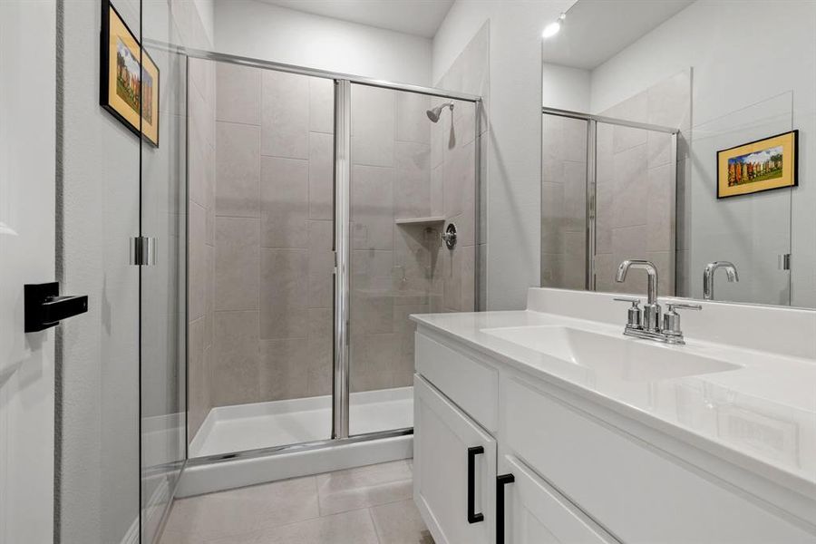 Bathroom featuring vanity, a shower stall, and light tile patterned floors