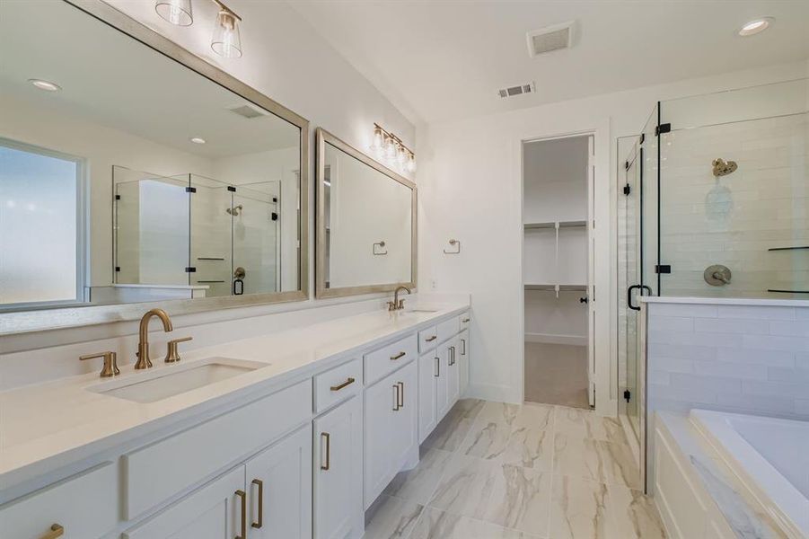 Bathroom featuring double vanity, a shower stall, recessed lighting, a garden tub, and a walk in closet