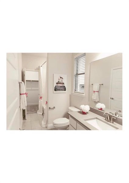 Bathroom featuring vanity, tile patterned floors, and toilet